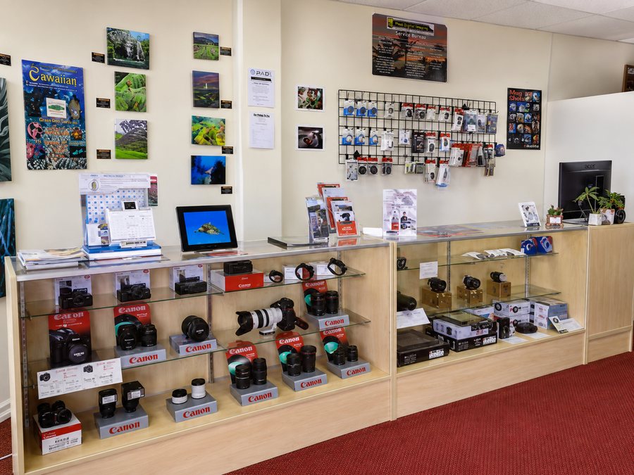 The Maui Digital Imaging retail counter, with Canon camera bodies and lenses laid out in a lit display case.